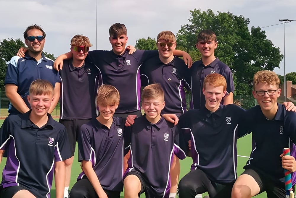 Eine Gruppe von Schülern in Sportuniformen posiert gemeinsam auf dem Sportfeld des Frome College.