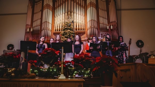 Eine Schülergruppe der Fulford Academy singt vor einer Orgel in einer festlich geschmückten Kirche.