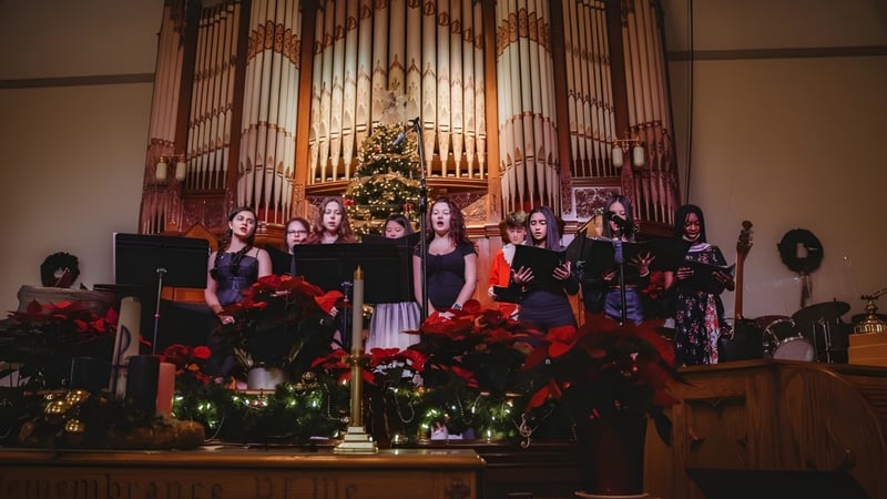 Eine Schülergruppe der Fulford Academy singt vor einer Orgel in einer festlich geschmückten Kirche.
