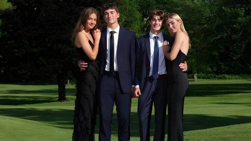 Vier Schüler der Fulford Academy posieren auf einer Wiese vor Bäumen.