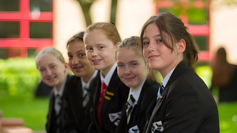 Eine Gruppe Schüler in Schuluniformen steht gemeinsam draußen auf dem Gelände der Fulston Manor.