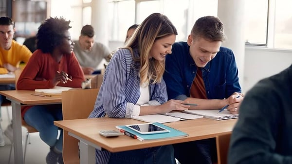 Eine Gruppe Schüler der Gallen Community School sitzt im Klassenraum und arbeitet gemeinsam an Aufgaben.