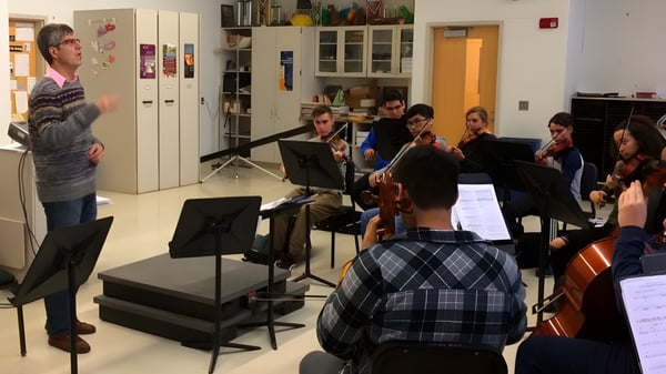 Eine Gruppe von Schülerinnen und Schülern mit Musikinstrumenten versammelt sich im Musikraum des Galway Community College.