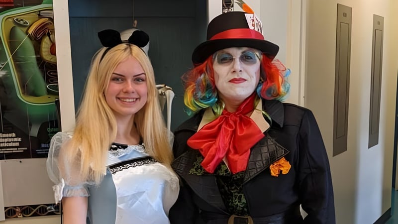 Zwei Personen in bunten Theaterkostümen stehen in einem Raum auf dem Campus der Gander Collegiate.