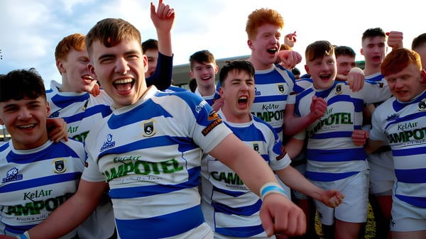 Eine Gruppe junger Rugbyspieler in blauen und weißen Trikots feiert auf dem Spielfeld des Garbally College.