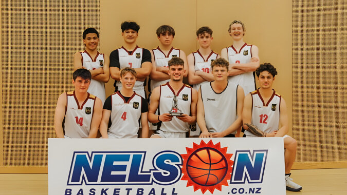 Eine Gruppe von Basketball spielenden Schülerinnen und Schülern posiert vor einem Nelson Basketball Banner auf dem Campus des Garin College.
