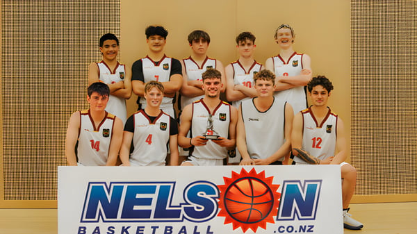 Eine Gruppe von Schülern des Garin College posiert in Basketballuniformen in der Sporthalle.