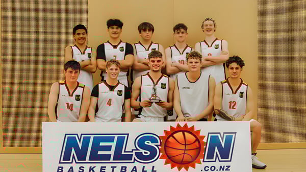 Eine Gruppe von Schülerinnen und Schülern des Garin College posiert in der Sporthalle mit einem Basketball-Pokal.