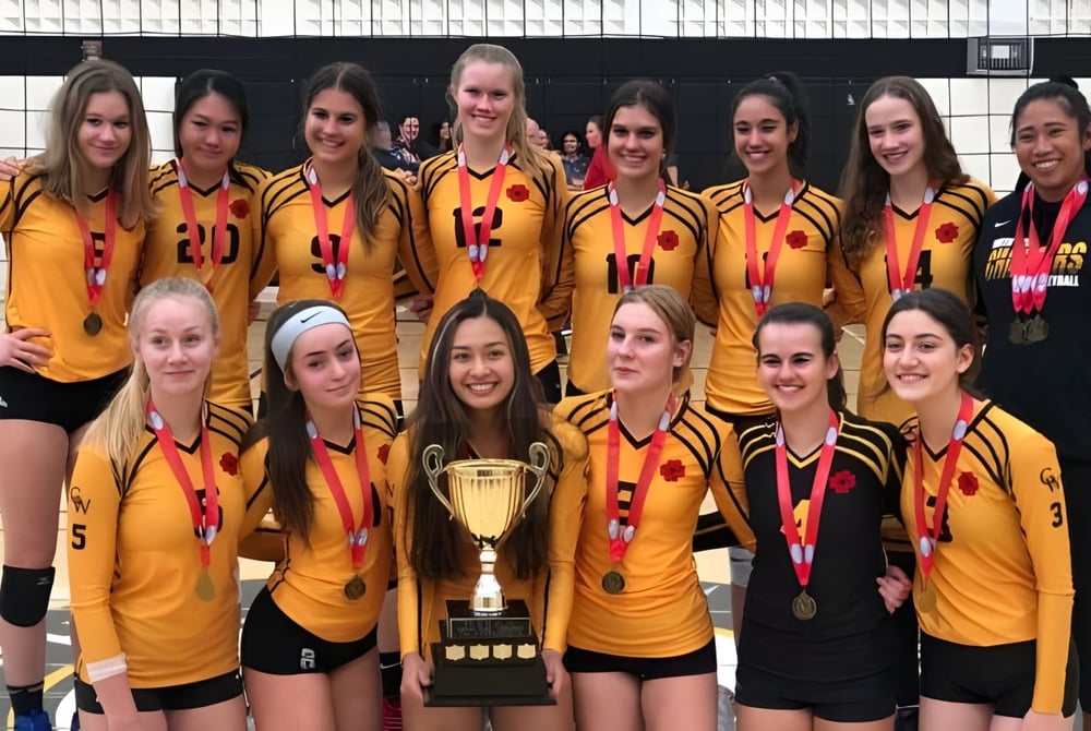 Eine Gruppe junger Athletinnen der Garth Webb Secondary School posiert mit einer Trophäe vor einer gefliesten Wand.