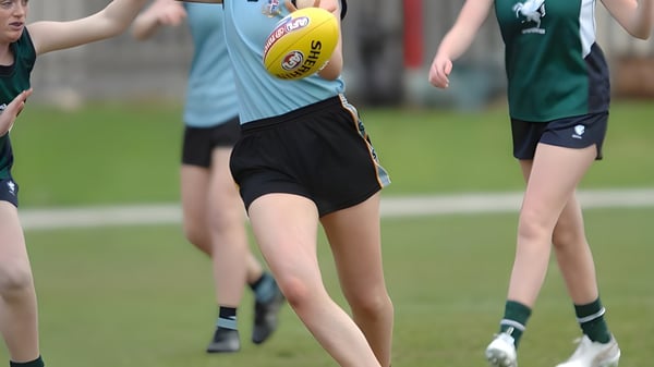 Schüler der Geelong Grammar School spielen Australian rules Football auf einem Rasenfeld.