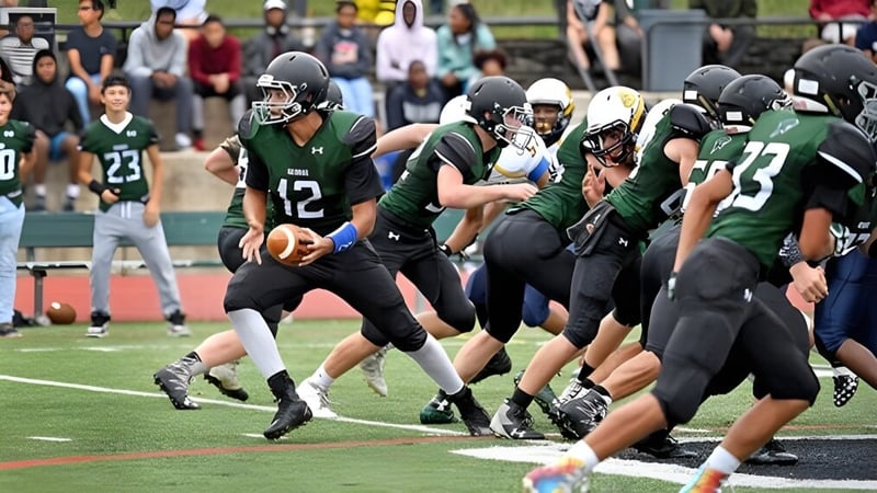 Schüler der George School spielen ein Fußballspiel auf dem Sportplatz mit Zuschauern im Hintergrund.