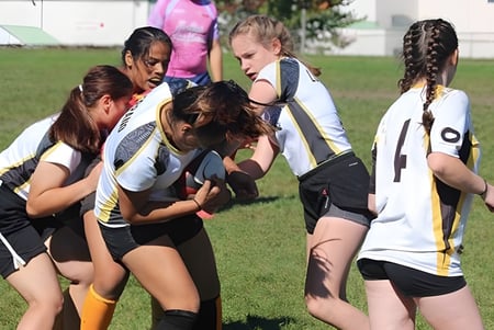 Eine Gruppe junger Sportlerinnen trainiert gemeinsam auf dem Sportplatz der Georges Vanier Secondary School.