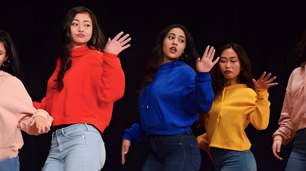 Eine Gruppe Schülerinnen der Georges Vanier Secondary School steht auf der Bühne und zeigt einen Ausdruck mit erhobenen Händen.