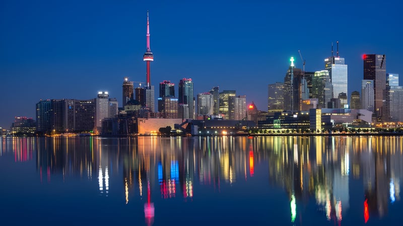 Beleuchtete Skyline einer Stadt mit reflektierenden Wolkenkratzern vor der Georgian Bay District Secondary School.