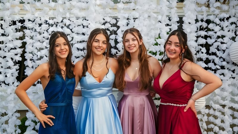 Vier Schülerinnen der Geraldine High School posieren gemeinsam vor einer Blumendekoration.