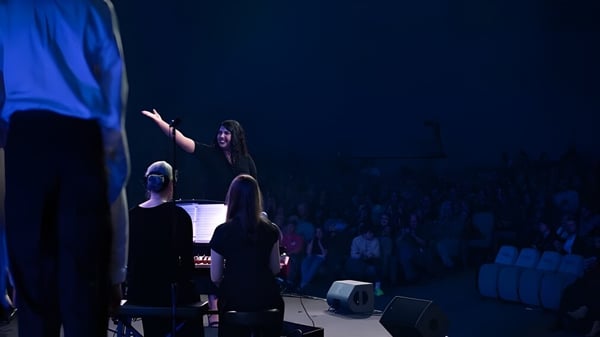 Eine Person tritt auf der Bühne vor großem Publikum in der Gilbert Christian Schools auf.