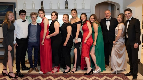 Eine Gruppe elegant gekleideter Personen posiert gemeinsam in einem formellen Raum auf dem Glenalmond College.