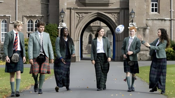 Schüler in Schuluniformen stehen vor dem gotischen Gebäude auf dem Campus des Glenalmond College.
