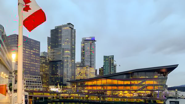 Eine kanadische Flagge weht vor der modernen Skyline der Stadt auf dem Gelände der Gleneagle Secondary School.