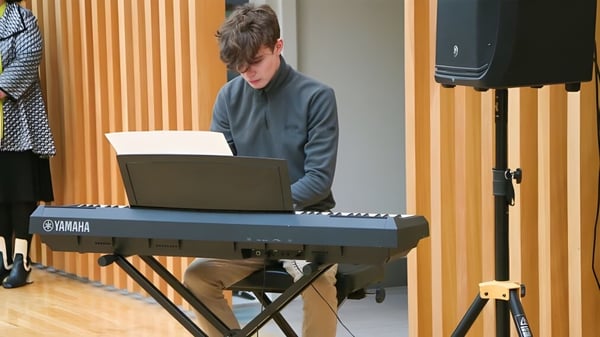 Ein Schüler der Glenstal Abbey School spielt konzentriert an einem Yamaha Keyboard mit Laptop davor.