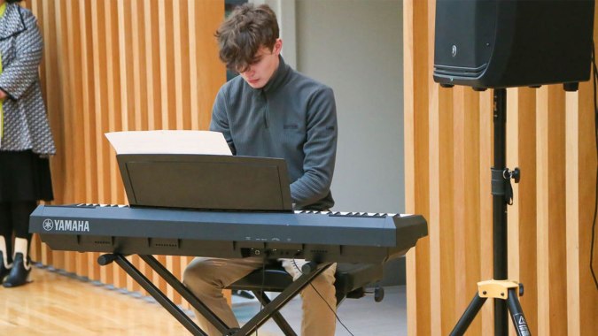 Ein Schüler der Glenstal Abbey School sitzt am Keyboard und arbeitet konzentriert an einem Laptop.