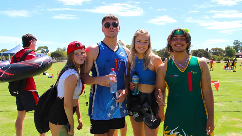 Eine Gruppe Schülerinnen und Schüler der Golden Grove High School posiert auf einer Wiese unter blauem Himmel.