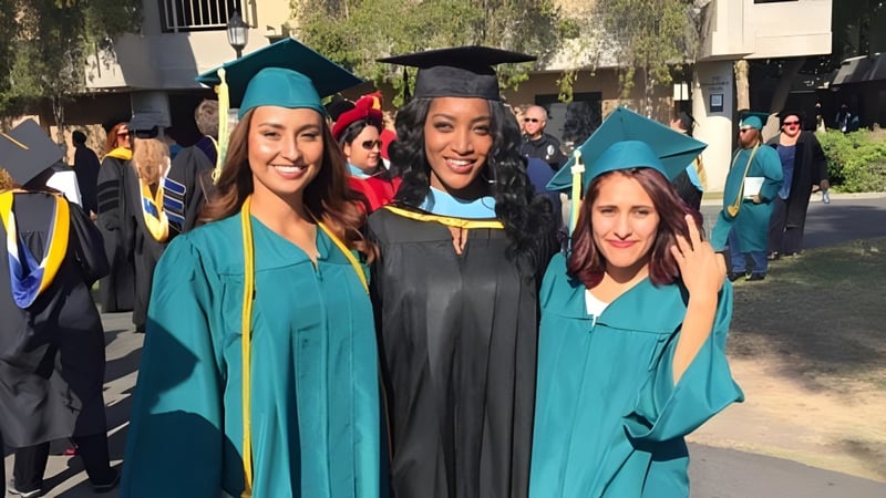 Eine Gruppe von Absolventinnen und Absolventen in grünen und schwarzen Abschlussroben feiert ihren Erfolg am Golden West College.