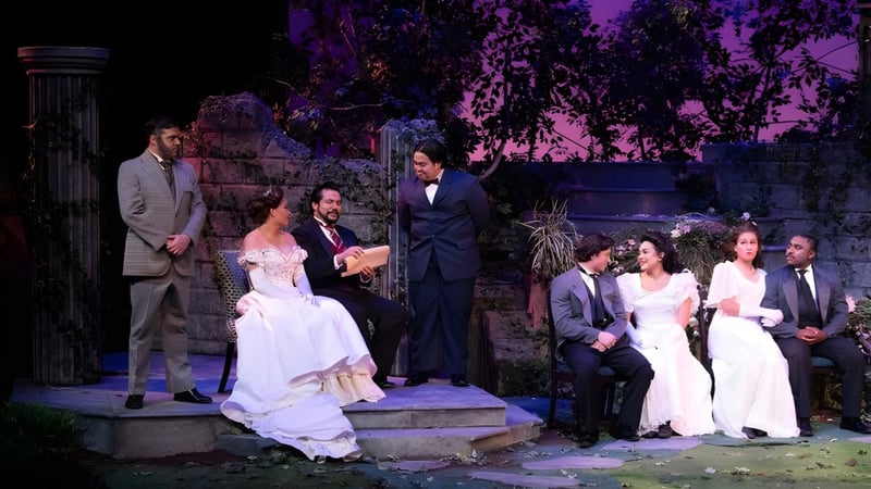 Eine formelle Hochzeitszeremonie findet auf dem Gelände des Golden West College im Freien vor einer grünen und violetten Kulisse statt.