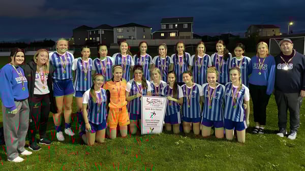 Eine Gruppe weiblicher Fußballspielerinnen der Gonzaga High School steht nachts gemeinsam auf einem Spielfeld.