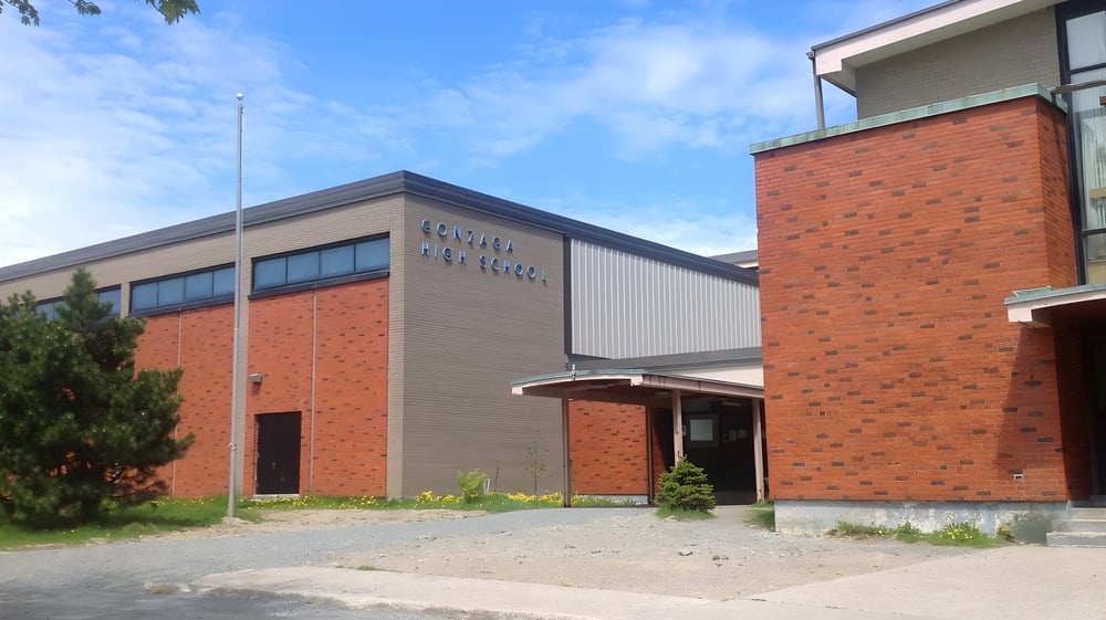 Das moderne Backsteingebäude der Gonzaga High School mit großem Eingangsbereich und Grünflächen davor.