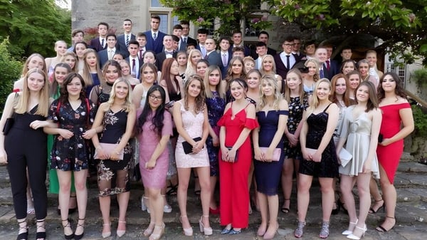 Eine Gruppe von Schülern der Gordonstoun School posiert vor einem Steinbau mit Grünpflanzen im Hintergrund.