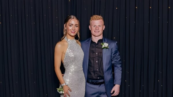 Ein Paar in formeller Kleidung steht vor einem schwarzen Vorhang auf dem Campus der Gore High School.