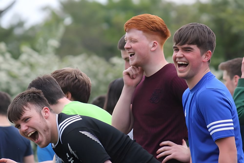 Eine Gruppe von Schülern der Gortnor Abbey steht draußen und unterhält sich lebhaft.