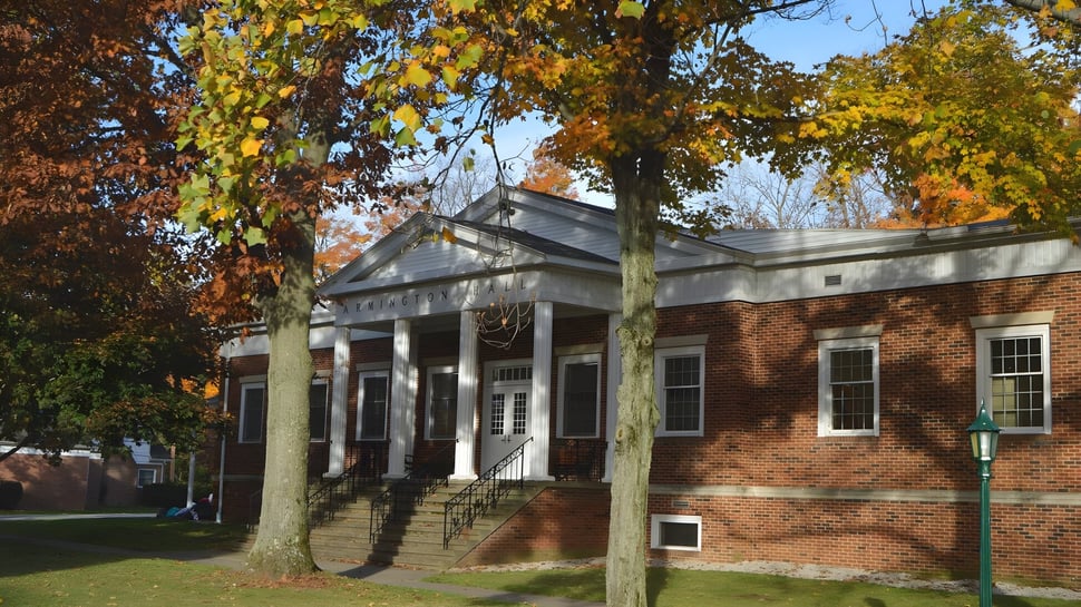 Das Backsteingebäude mit Säulenveranda steht auf dem Gelände der Grand River Academy im herbstlichen Umfeld.