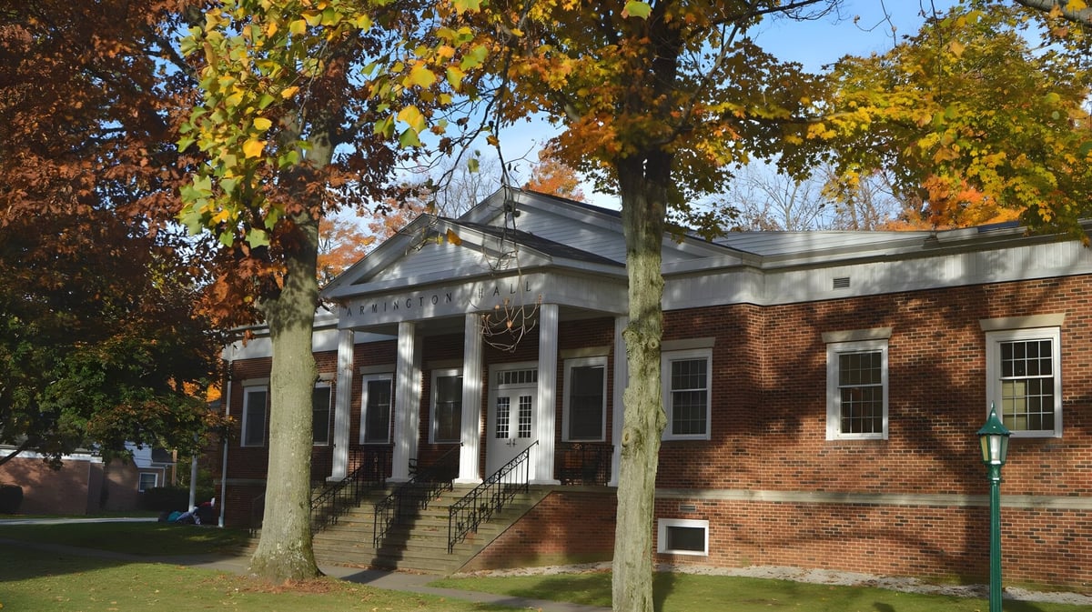 Das Backsteingebäude mit Säulenveranda steht auf dem Gelände der Grand River Academy im herbstlichen Umfeld.