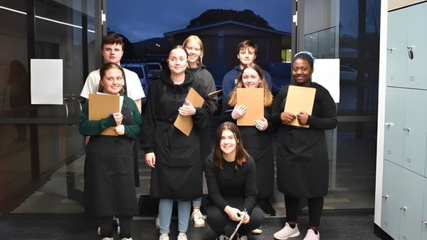 Eine Gruppe Schüler steht nachts mit Ordnern vor einem Gebäude auf dem Gelände der Grant High School.