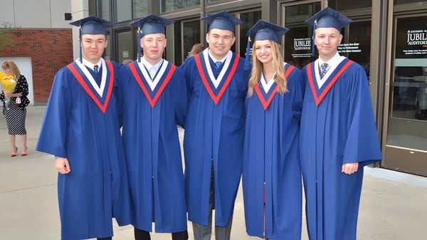 Fünf Schüler der Grant Park High School tragen blaue Abschlusskleidung vor einem Schulgebäude.
