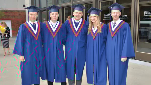Fünf Schüler der Grant Park High School tragen blaue Abschlusskleidung vor einem Schulgebäude.