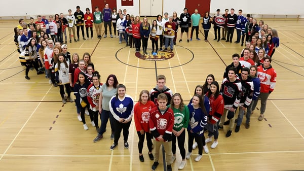 Schüler der Gravenhurst High School bilden in der Sporthalle eine Herzform mit ihren Körpern.
