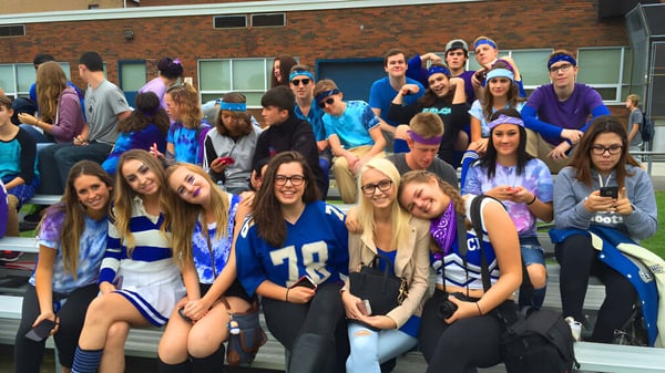 Eine Gruppe Schülerinnen und Schüler der Great Lakes District Secondary School steht vor einem Backsteingebäude.