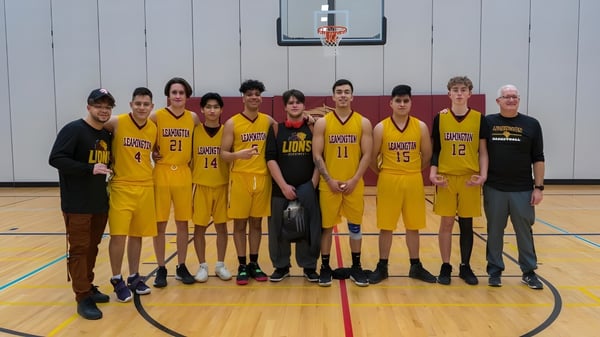 Eine Gruppe junger Basketballspielerinnen und -spieler steht gemeinsam auf dem Basketballfeld des Greater Essex County District School Board.