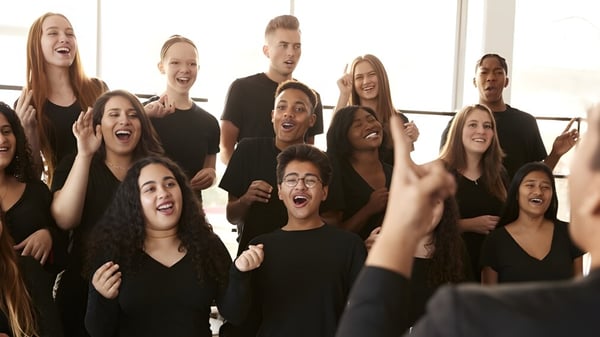 Schüler des Green Bay Area Public School District feiern gemeinsam in einem Probensaal mit großen Fenstern.