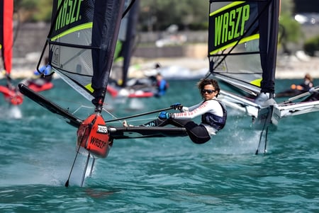 Eine Schülerin der Green Bay High School segelt mit einem kleinen Segelboot auf einem Gewässer.
