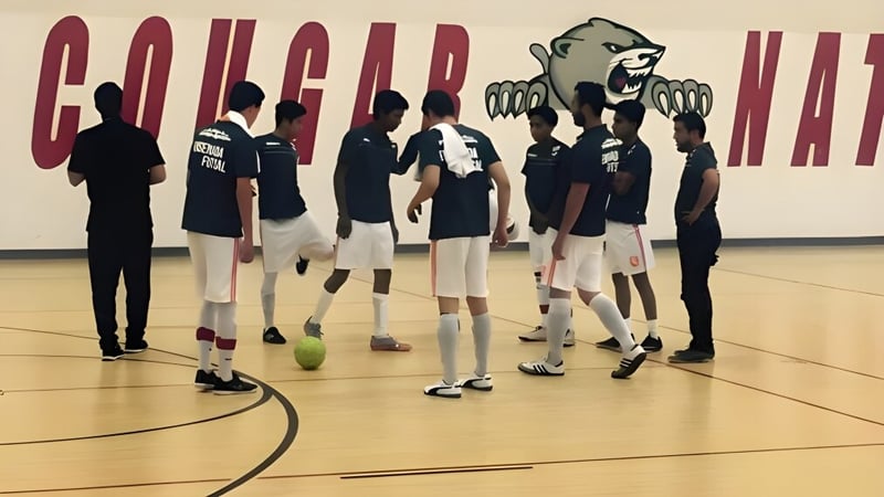 Eine Gruppe Schülerinnen und Schüler der Green Fields High School steht gemeinsam auf dem Basketballfeld vor einem großen Wandgemälde.