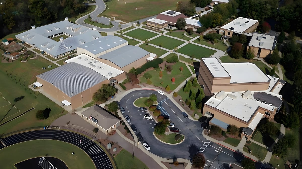 Luftaufnahme des weitläufigen Campus der Greensboro Day School mit Gebäuden und grünen Landschaftsflächen.