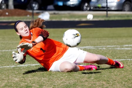 Eine Fußballspielerin fängt den Ball auf dem Spielfeld der Greensboro Day School.