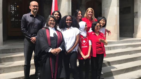 Eine Gruppe von Schülerinnen und Schülern der Greenwood Secondary School posiert auf der Treppe vor einem Gebäude nach der Abschlussfeier.