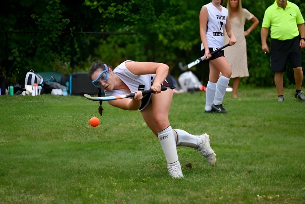 Ein Schüler des Groton-Dunstable Regional School District macht einen Kopfstand auf einer Wiese mit weiteren Schülern im Hintergrund.