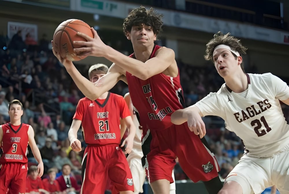 Zwei Basketballspielerinnen in roten und weißen Trikots kämpfen um den Ball auf dem Spielfeld der Guelph Collegiate Vocational Institute.