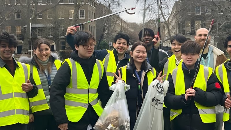 Schüler der Guildhouse School London stehen gemeinsam in Sicherheitswesten im Stadtgebiet.